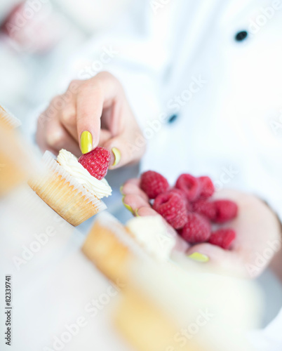 Chef hands decorating cupcakes