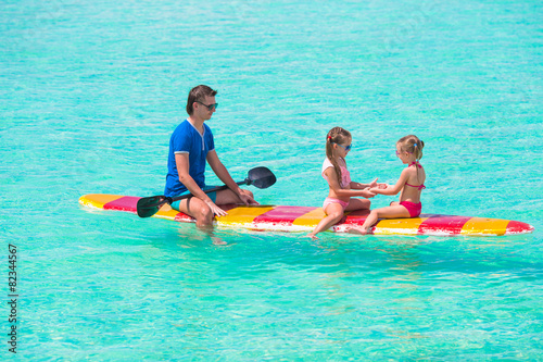 Father and kids on surfboard during summer vacation