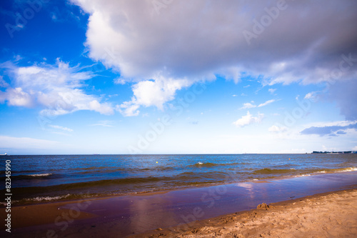 Fototapeta Naklejka Na Ścianę i Meble -  View of cloudy sky at sea with footprints on a beach