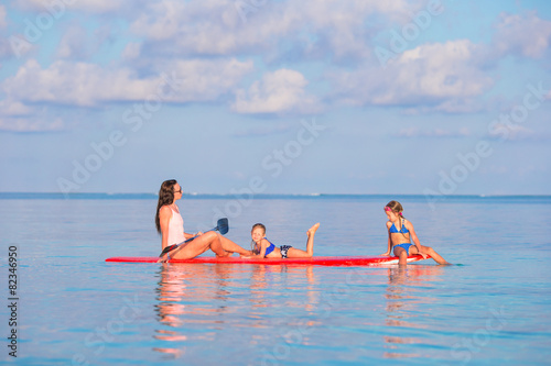 Mother and little girls on surfboard during summer vacation © travnikovstudio