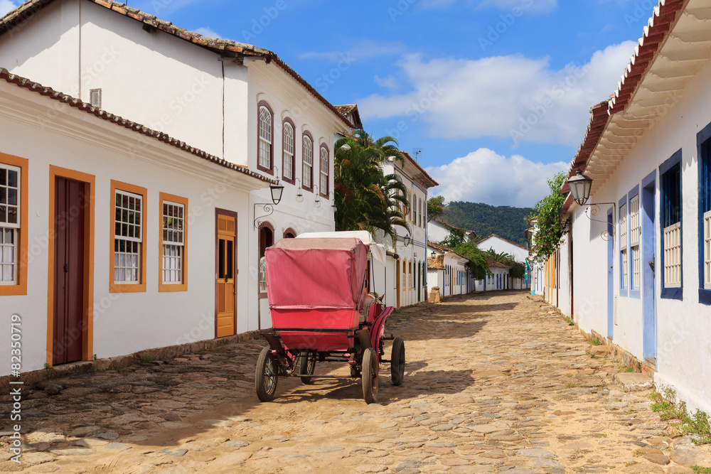 Coach on street, old colonial houses in Paraty, Brazil