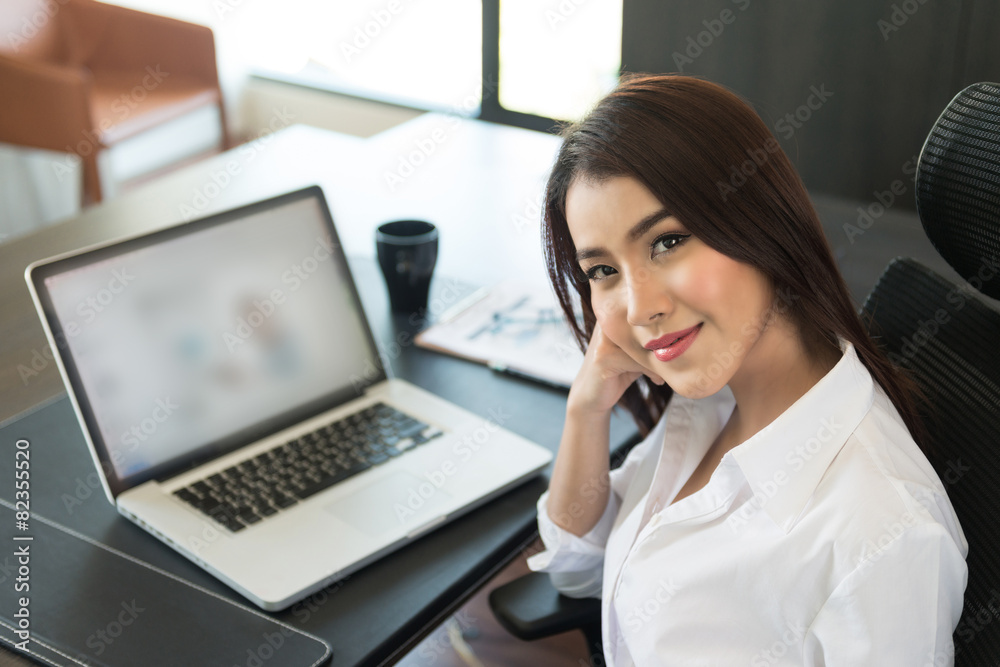 Portrait of a young business woman using laptop at office Portrait of a young business woman using laptop at office