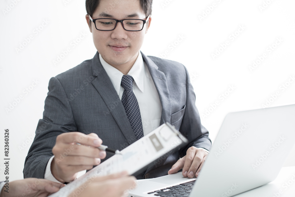 Two businessmen looking at report and having a discussion in off Two businessmen looking at report and having a discussion in off