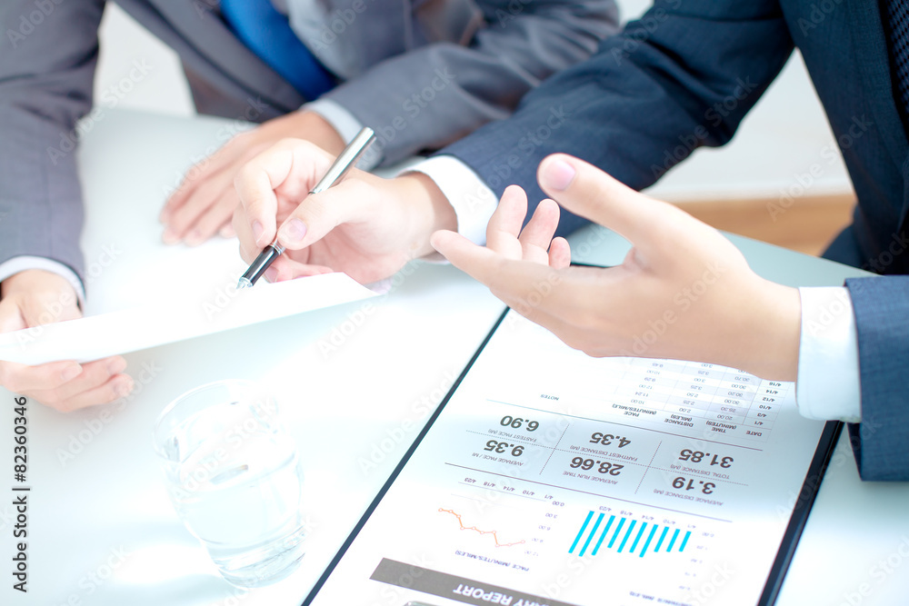 Two businessmen looking at report and having a discussion in off Two businessmen looking at report and having a discussion in off