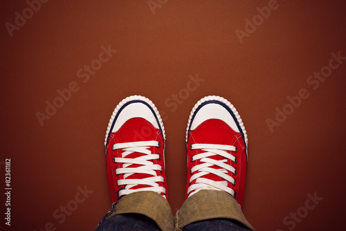 Feet From Above, Teenager in Sneakers Standing on Brown Backgrou
