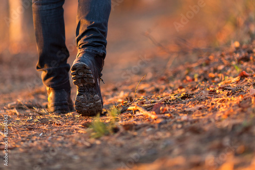 Closeup of woman legs hiking in nature at sunset. photo