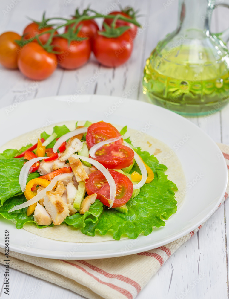 Roasted chicken fillet on wheat tortilla with fresh vegetables