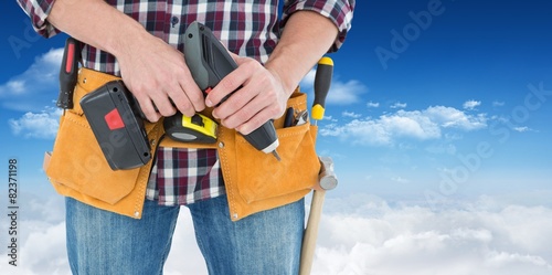 Composite image of male repairman holding drill machine © WavebreakmediaMicro