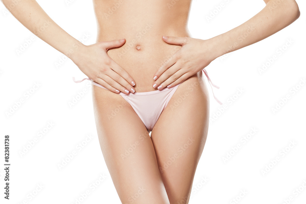 young woman holding hands on her stomach, over the ovary