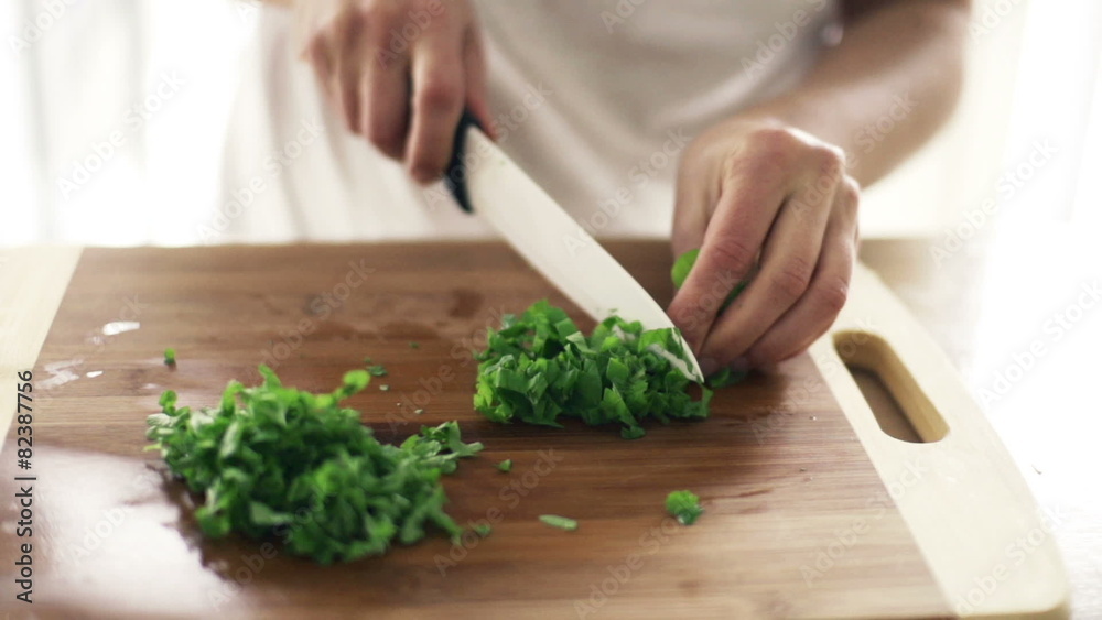 Woman slicing basil in kitchen, slow motion shot at 240fps
Woman slicing basil in kitchen, slow motion shot at 240fps