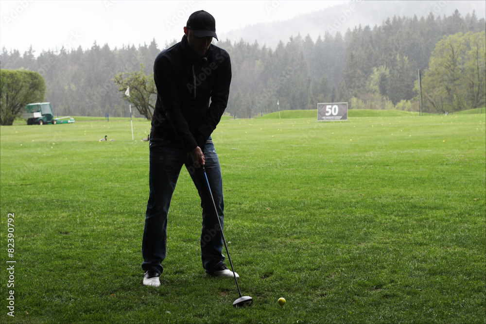 Obraz premium Golfer beim Abschlag im Regen