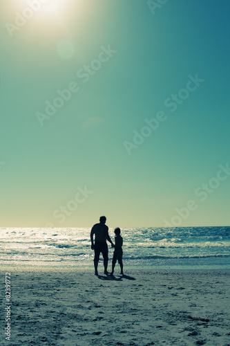 father and son walking on the beach