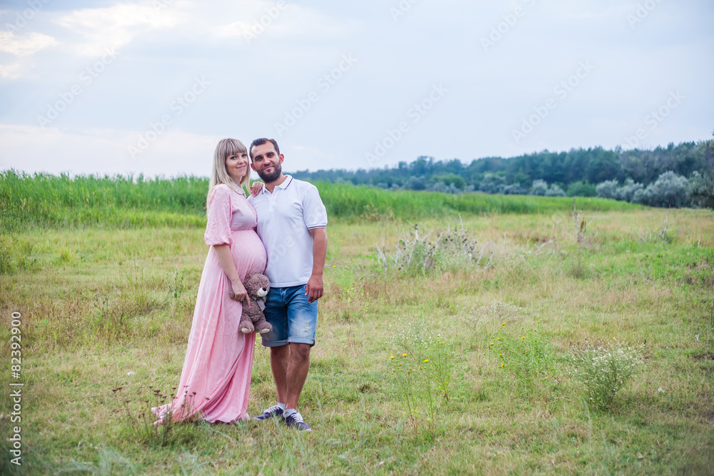 man and pregnant woman on nature