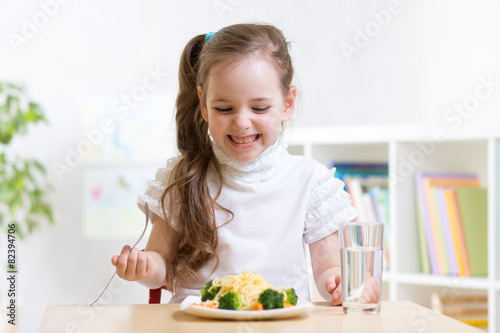 joyful child eating healthy food at home
