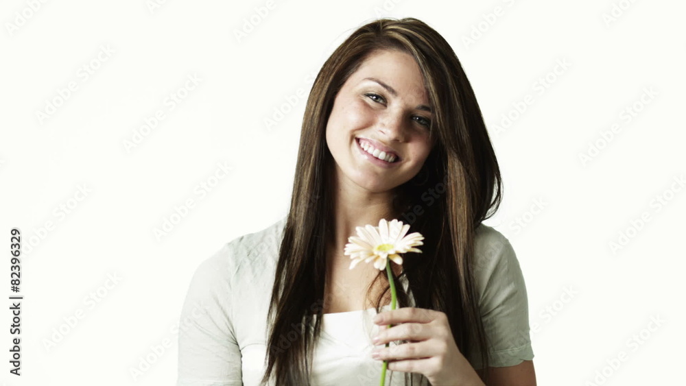 MS Portrait of young woman smelling flower against white background / Orem, Utah, USA MS Portrait of young woman smelling flower against white background / Orem, Utah, USA
