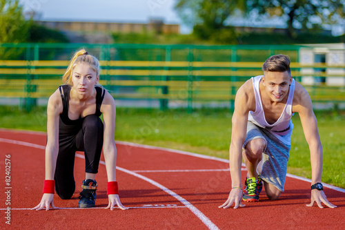 Young sport couple in starting position prepared to compete and