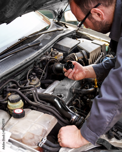 Close up of auto mechanic opens the oil cap