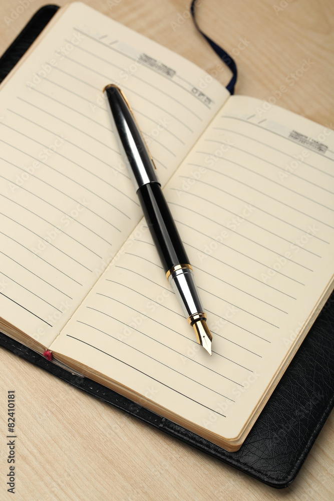 Writing pen and notebook on wooden table, closeup Writing pen and notebook on wooden table, closeup