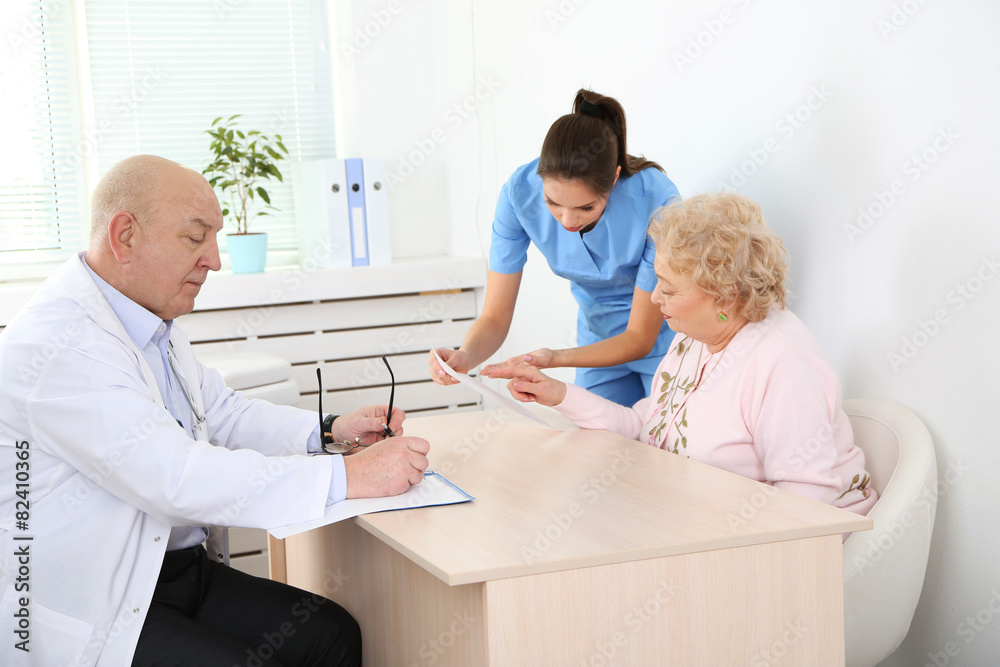 Obraz premium Happy doctors and patient in hospital clinic