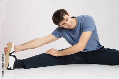 Man in training stretches muscles of the right leg