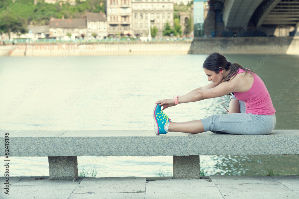 Woman stretching her leg by the river after running... Woman stretching her leg by the river after running...
