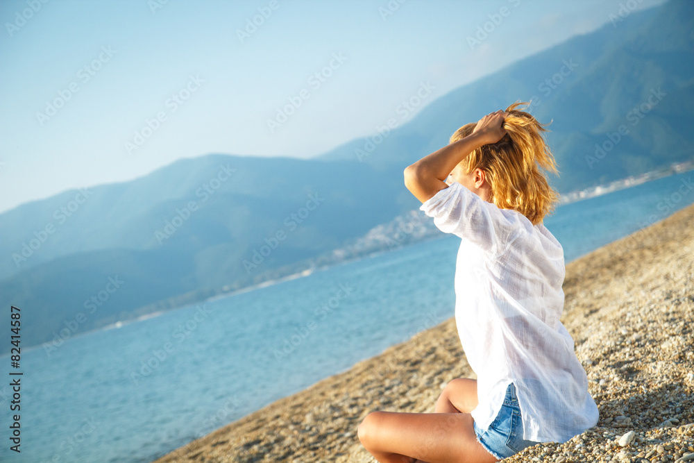 Young woman relaxing on the beach in the morning.