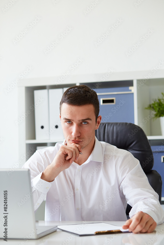 Pensive young businessman with notebook