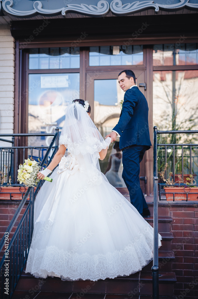Bride and groom standing on stairs