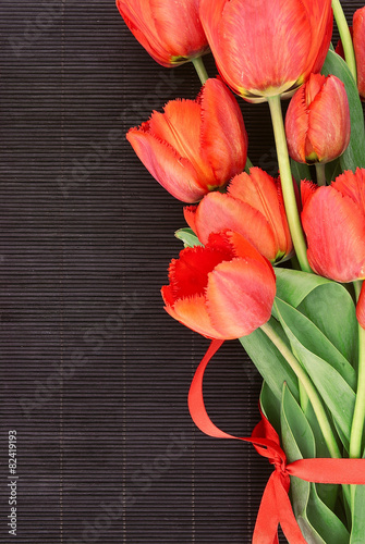 Fototapeta Naklejka Na Ścianę i Meble -  Bouquet of red tulips on dark background with space for message.