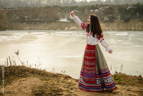 young woman in Slavic Belarusian national original suit outdoors