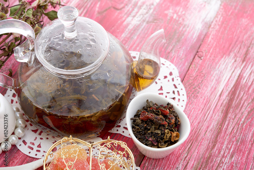 cinnamon and fruit drink in glass teapot on wooden background