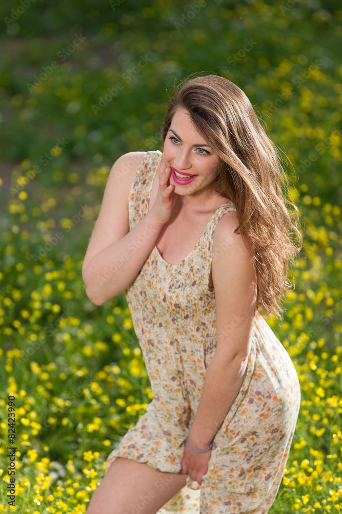 Beautiful young girl among yellow flowers