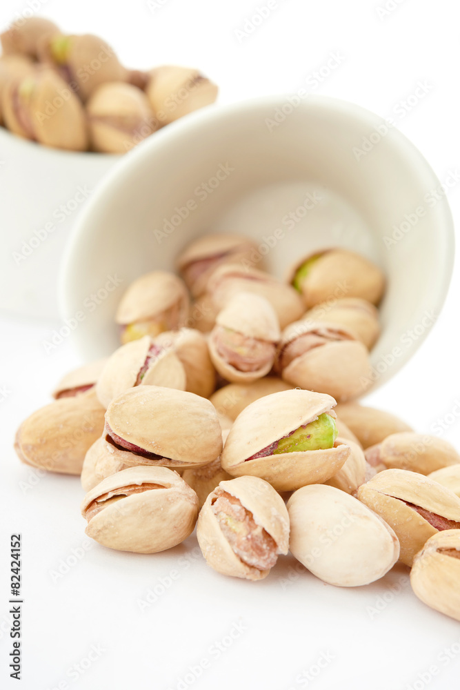 Fototapeta premium Heap of pistachios nuts isolated on the white
