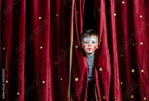 Murais de parede Boy Clown Peering Through Stage Curtains
