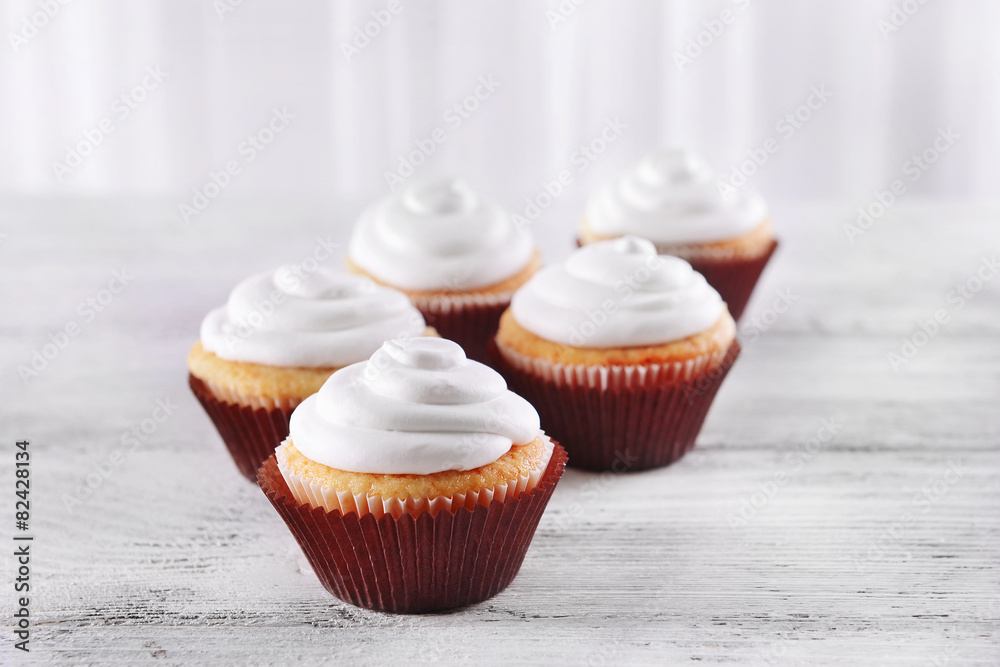 Delicious cupcakes on table on light background Delicious cupcakes on table on light background