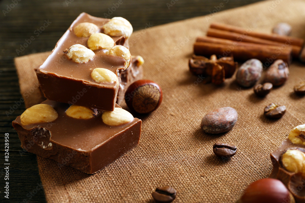 Delicious chocolates with nuts spices on table, closeup Delicious chocolates with nuts spices on table, closeup