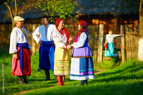happy ukrainian family in traditional costumes talking outdoor