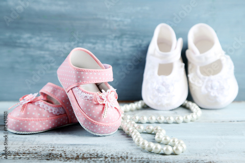 Pink and white toddler shoes on wooden background