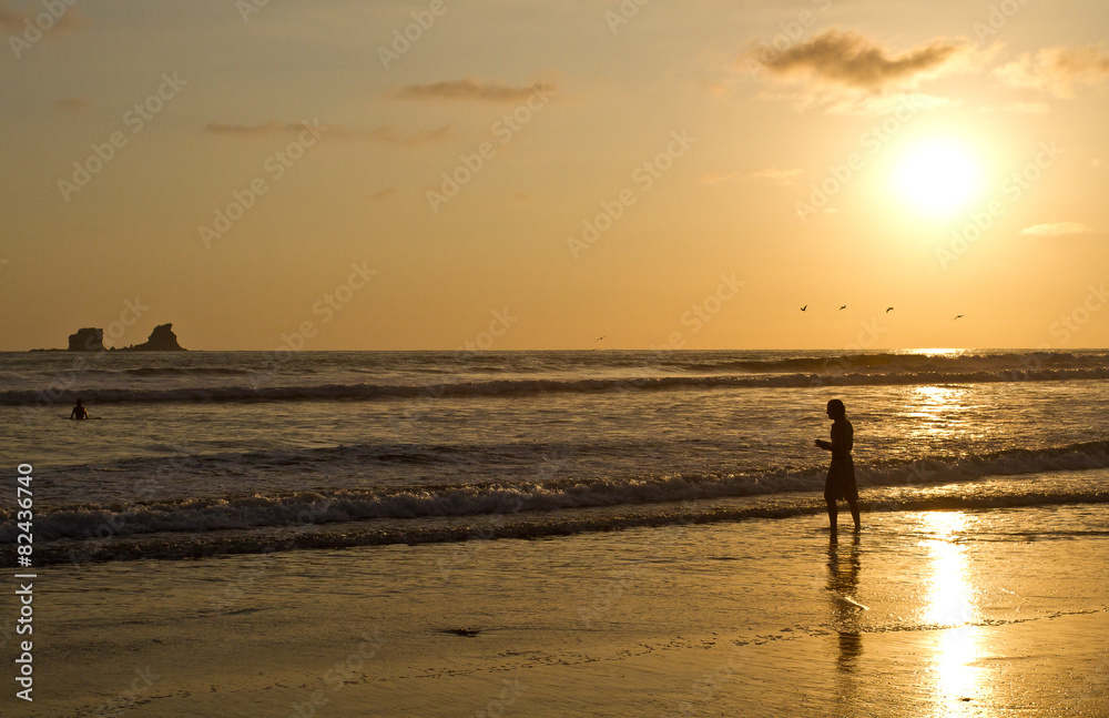 Silhouette of young man enjoying the beach view during sunset