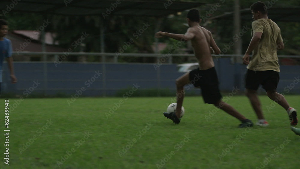 Wide slow motion panning shot of soccer teams playing on field / Esterillos, Puntarenas, Costa Rica Wide slow motion panning shot of soccer teams playing on field / Esterillos, Puntarenas, Costa Rica