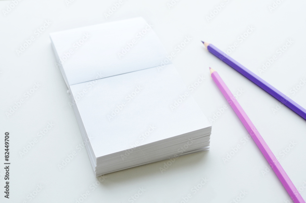 Empty note paper block and two pencils on light background Empty note paper block and two pencils on light background