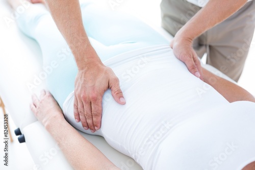 Physiotherapist examining his patients stomach