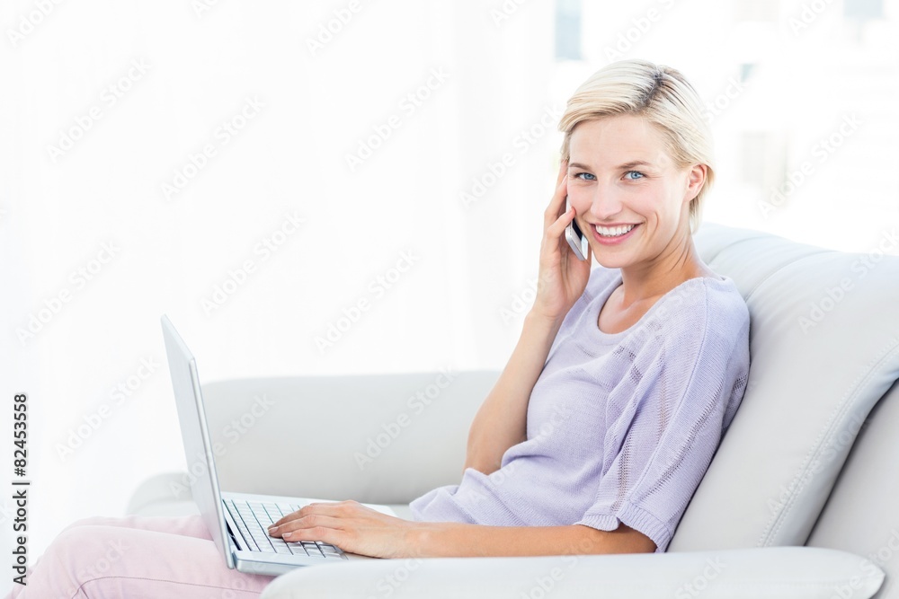 Pretty blonde woman calling on the phone and using her laptop Pretty blonde woman calling on the phone and using her laptop