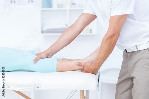 Physiotherapist doing leg massage to his patient