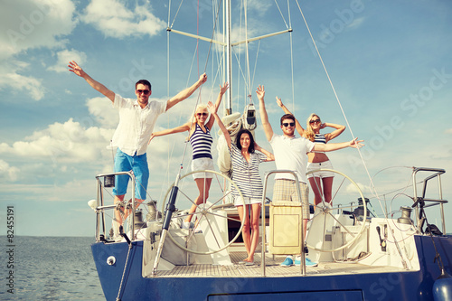 smiling friends sitting on yacht deck and greeting