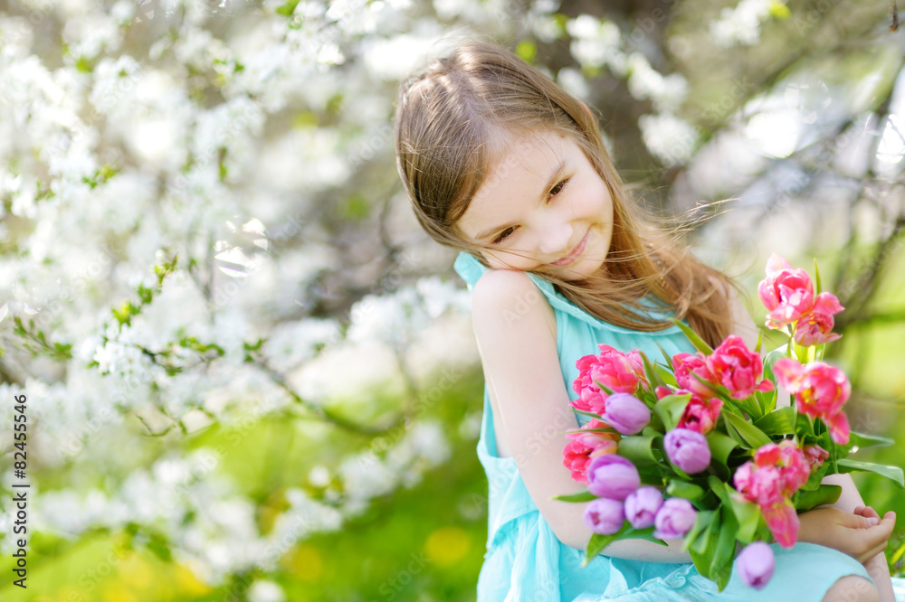 Adorable little girl in blooming cherry garden Adorable little girl in blooming cherry garden