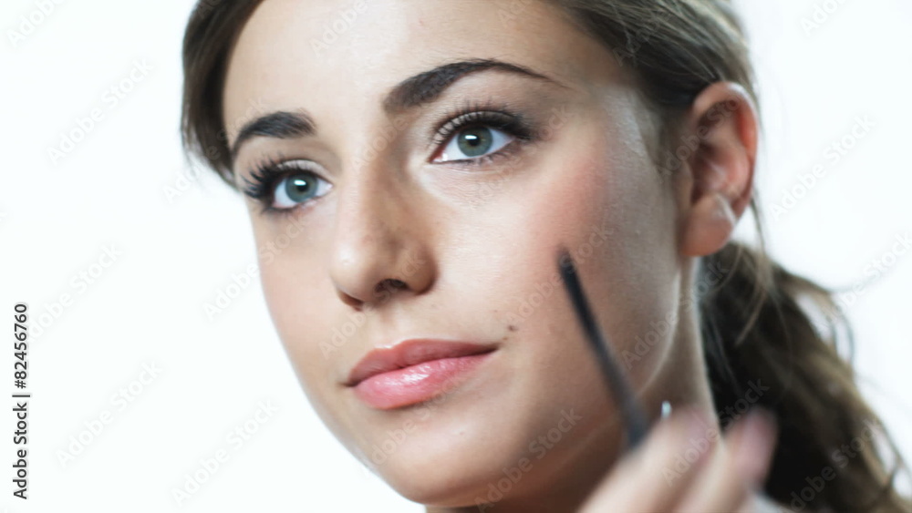 young woman applying mascara young woman applying mascara