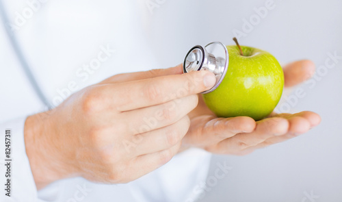 male doctor with green apple and stethoscope