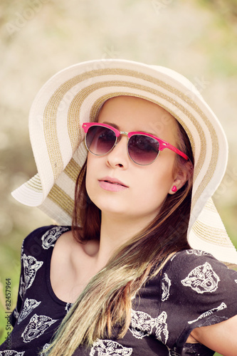 Cheerful fashionable woman in stylish hat, frock and sunglasses