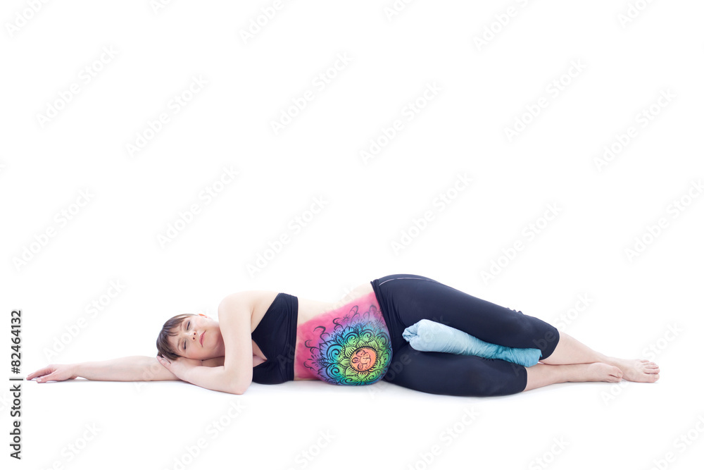 Pregnant woman with painted belly doing yoga exercise Pregnant woman with painted belly doing yoga exercise